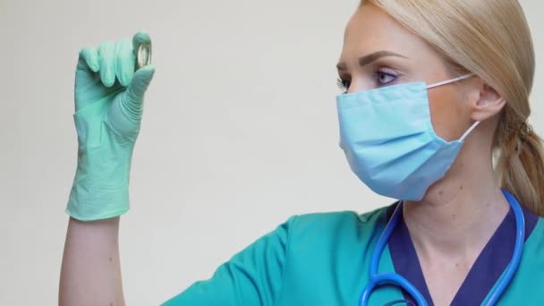 Medische arts verpleegkundige vrouw dragen beschermende masker en rubber of latex handschoenen - Holding pillen — Stockvideo