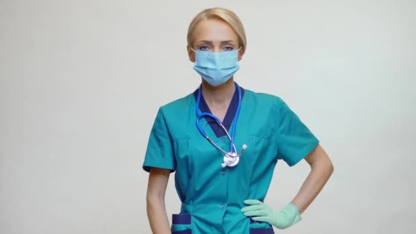 Medic asistentă medicală femeie care poartă mască de protecție și mănuși de cauciuc sau latex - care dețin pastile — Videoclip de stoc