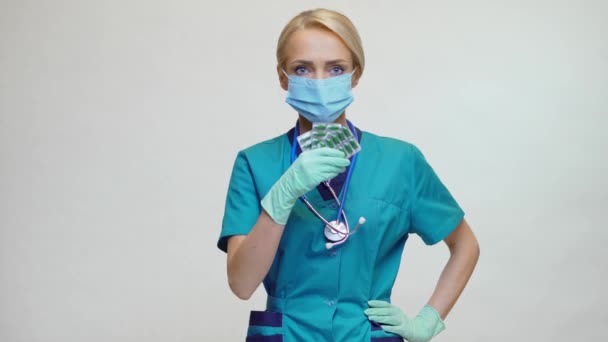 보호 마스크와 고무나 라텍스 장갑을 착용하고 있는 의사 간호사 - 약을 들고 있는 모습 — 비디오