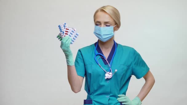 Médico enfermera mujer con máscara protectora y guantes de goma o látex - píldoras de retención — Vídeo de stock