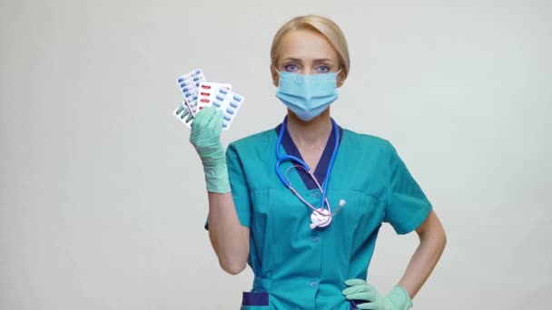 Medische arts verpleegkundige vrouw dragen beschermende masker en rubber of latex handschoenen - Holding pillen — Stockvideo