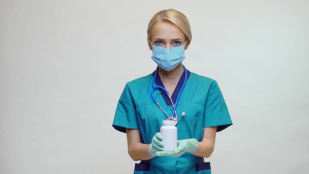Ärztin Krankenschwester mit Schutzmaske - Dose mit Pillen oder Vitaminen — Stockvideo