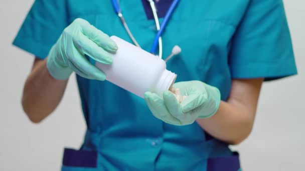 Medical doctor nurse woman wearing protective mask - holding can of pills or vitamins — Stock Video