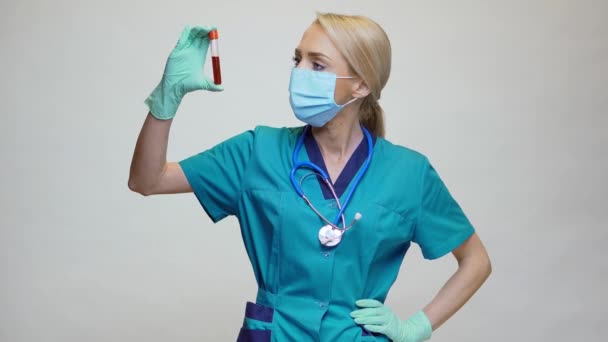 医生护士戴防护面罩及乳胶手套的妇女-持血试管 — 图库视频影像