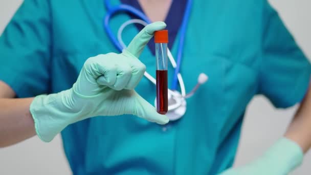 Medical doctor nurse woman wearing protective mask and latex gloves - holding blood test tube — Stock Video