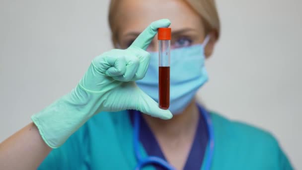 Orvos Nővér Nő Viselő Védő Maszk és Latex kesztyű - Holding Blood Test Tube — Stock videók
