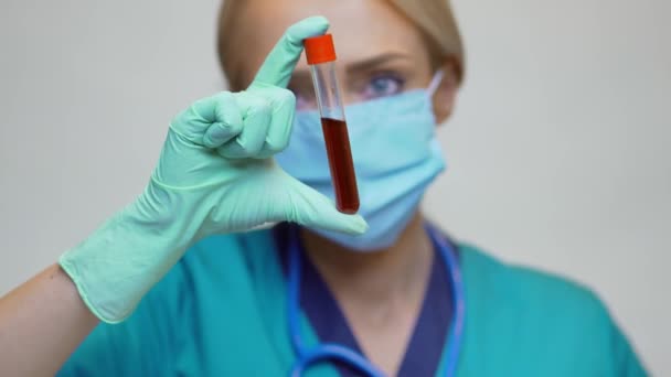 Врач медсестра женщина в защитной маске и латексных перчатках - проведение пробирки крови — стоковое видео