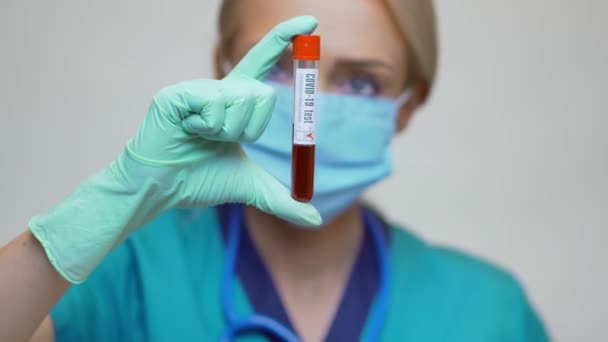 Врач медсестра женщина в защитной маске и перчатках - проведение COVID-19 положительный анализ крови — стоковое видео