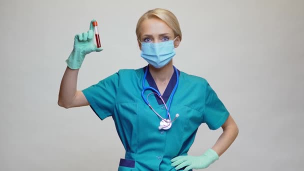 医師看護師女性身に着けています保護マスクとラテックス手袋-ホールディング血液検査チューブ — ストック動画