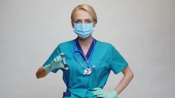 Lekarz pielęgniarka kobieta w masce ochronnej i rękawiczkach - trzymając COVID-19 ujemny wynik badania krwi — Wideo stockowe