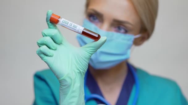 Medical doctor nurse woman wearing protective mask and gloves - holding COVID-19 blood test — Stock Video