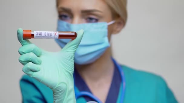 보호 마스크를 쓰고 장갑을 끼고 있는 의사 간호사 COVID-19 양성 혈액 검사를 하는 여성 — 비디오