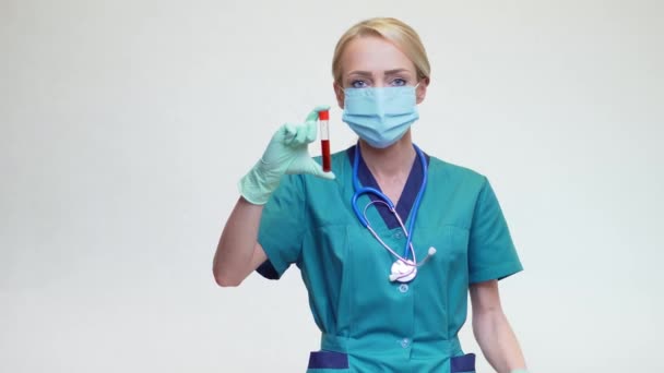 Médico enfermera mujer con máscara protectora y guantes de látex - sosteniendo el tubo de análisis de sangre — Vídeo de stock