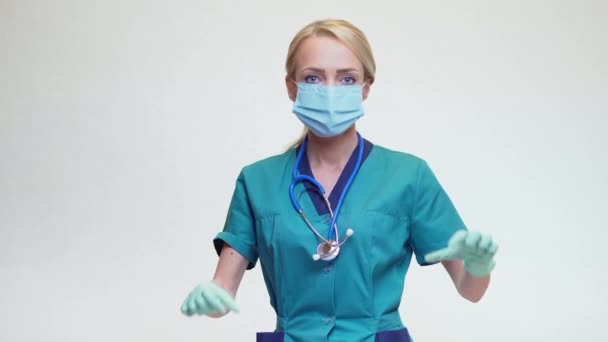 Доктор показывает форму сердца своими руками в стерильных перчатках — стоковое видео