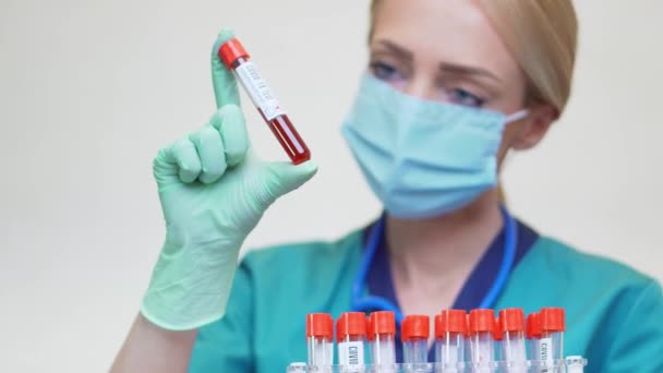 Medical doctor nurse woman wearing protective mask and latex gloves - holding blood test tube rack — Stock Video