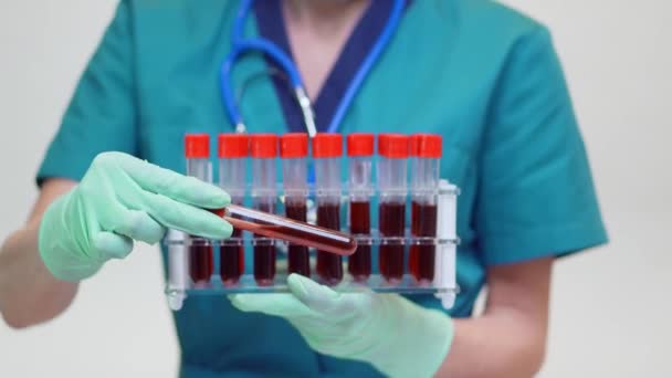 Médico enfermera mujer con máscara protectora y guantes de látex - celebración de estante de tubo de análisis de sangre — Vídeo de stock