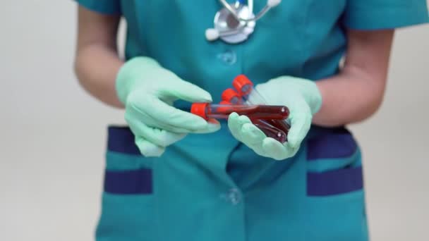 Médico enfermera mujer con máscara protectora y guantes de látex - sosteniendo el tubo de análisis de sangre — Vídeo de stock