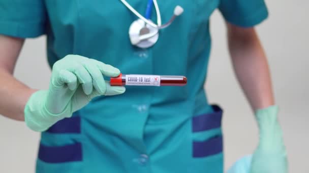 Médico enfermeira mulher vestindo máscara protetora e luvas de látex - segurando tubo de teste de sangue — Vídeo de Stock
