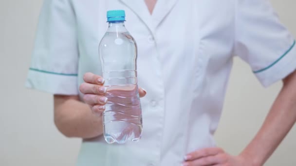 Ernährungsberaterin oder Diätassistentin Ärztin Konzept eines gesunden Lebensstils - Flasche Wasser in der Hand — Stockvideo