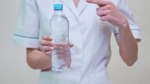 Vrouwelijke vrouw voedingsdeskundige of diëtist arts gezonde levensstijl concept - vasthouden fles water — Stockvideo
