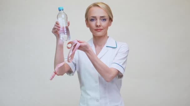 Ernährungswissenschaftler Arzt Konzept eines gesunden Lebensstils - Wasserflasche und Maßband in der Hand — Stockvideo