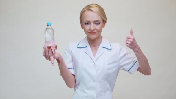Dietetyk lekarz zdrowy styl życia koncepcja - trzymając butelkę wody i taśmę pomiarową — Wideo stockowe