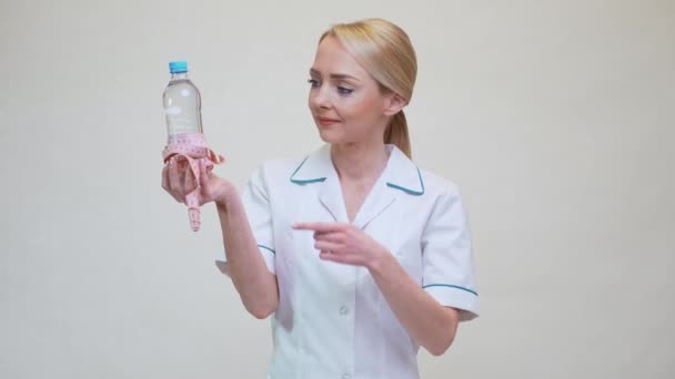 Dietetyk lekarz zdrowy styl życia koncepcja - trzymając butelkę wody i taśmę pomiarową — Wideo stockowe
