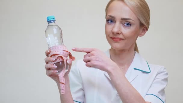 Nutritionist läkare hälsosam livsstil koncept - hålla flaska vatten och mäta tejp — Stockvideo