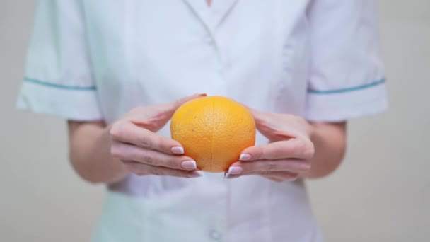 Nutricionista médico conceito de estilo de vida saudável - segurando frutas laranja — Vídeo de Stock