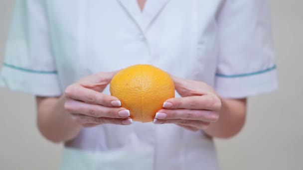 Nutricionista médico concepto de estilo de vida saludable - la celebración de fruta naranja — Vídeos de Stock