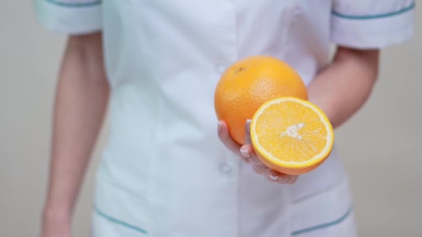 Nutricionista médico concepto de estilo de vida saludable - la celebración de fruta naranja — Vídeos de Stock