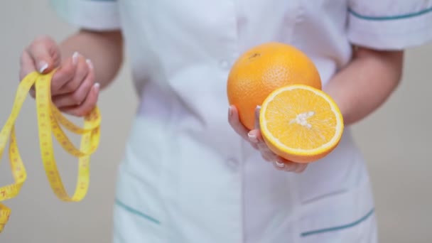Diyetisyen doktor sağlıklı yaşam tarzı konsepti - portakal meyvesi tutmak — Stok video