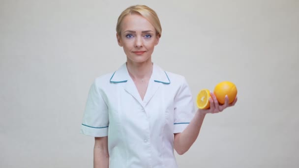 Nutriční lékař zdravý životní styl koncept - držení pomerančového ovoce — Stock video