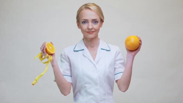 Nutritionist doctor healthy lifestyle concept - holding orange fruit — Stock Video