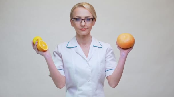 Nutriční lékař zdravý životní styl koncept - držení pomeranče, grapefruitu a citronového ovoce — Stock video