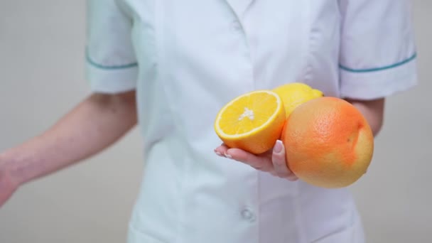 Nutricionista médico concepto de estilo de vida saludable - la celebración de naranja, pomelo y fruta de limón — Vídeos de Stock