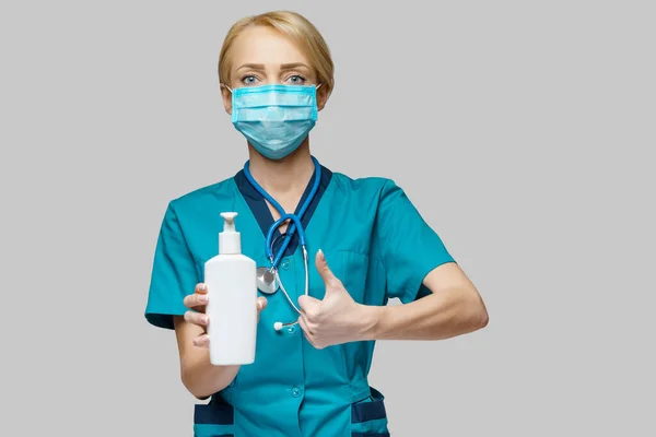 Medical doctor nurse wearing protective mask - holding hand sanitizer spray or gel or liquid soap — Stock Photo, Image