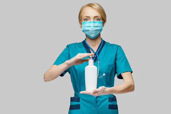 Enfermera médica que usa máscara protectora - que sostiene el aerosol desinfectante de la mano o gel o jabón líquido —  Fotos de Stock
