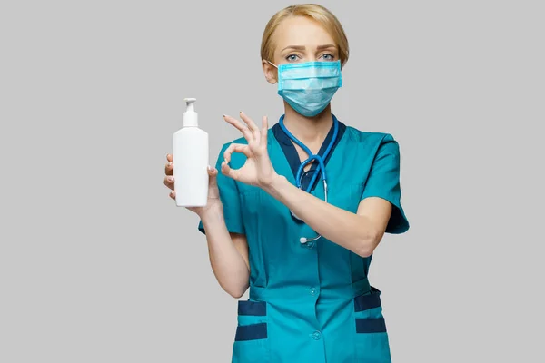 보호가 되는 마스크를 쓰고 있는 의사 간호사 스프레이나 젤이나 액상 비누를 사용하는 모습 — 스톡 사진