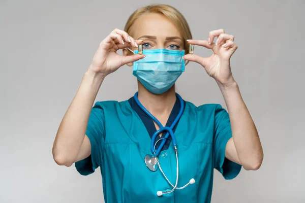 Medische arts verpleegkundige vrouw dragen beschermende masker en rubber of latex handschoenen - Holding pillen — Stockfoto