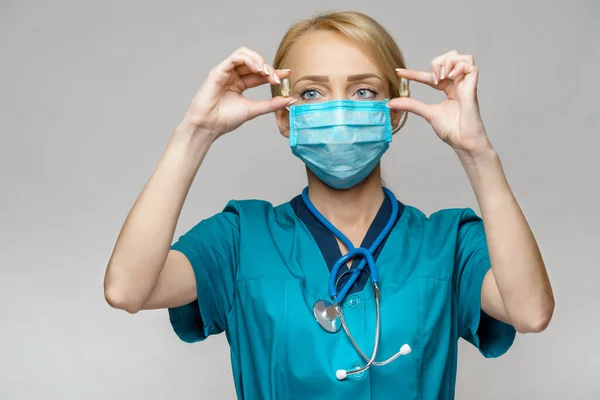 Médico enfermera mujer con máscara protectora y guantes de goma o látex - píldoras de retención —  Fotos de Stock