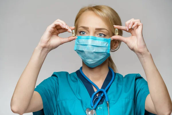 Medische arts verpleegkundige vrouw dragen beschermende masker en rubber of latex handschoenen - Holding pillen — Stockfoto