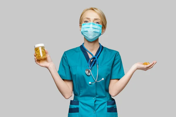 Medical doctor nurse woman wearing protective mask and rubber or latex gloves - holding can of pills — Stock Photo, Image