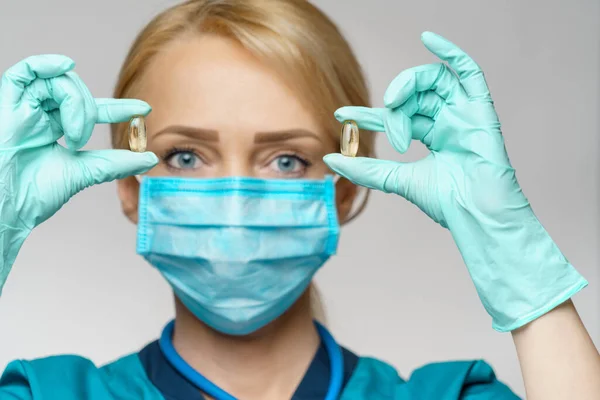 Médico enfermera mujer con máscara protectora y guantes de goma o látex - píldoras de retención —  Fotos de Stock