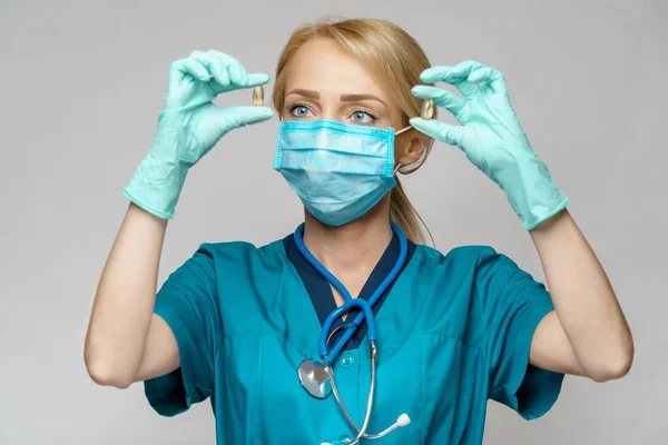 Médico enfermera mujer con máscara protectora y guantes de goma o látex - píldoras de retención — Foto de Stock