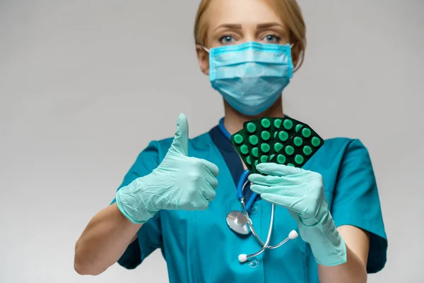 Orvos nővér nő visel védő maszk és gumi vagy latex kesztyű - gazdaság hólyagok tabletták — Stock Fotó