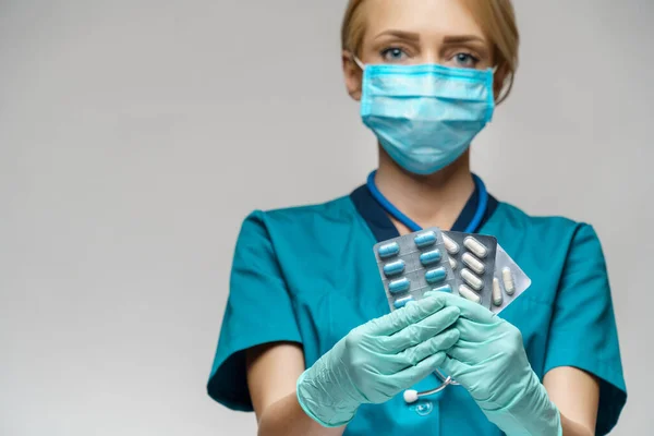 Verpleegkundige vrouw met beschermend masker en rubber of latex handschoenen - met blaren van pillen — Stockfoto