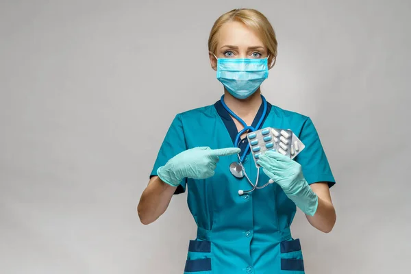 Orvos nővér nő visel védő maszk és gumi vagy latex kesztyű - gazdaság hólyagok tabletták — Stock Fotó