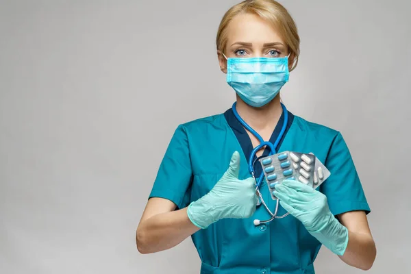 Médico enfermera mujer con máscara protectora y guantes de goma o látex - que contiene ampollas de píldoras —  Fotos de Stock
