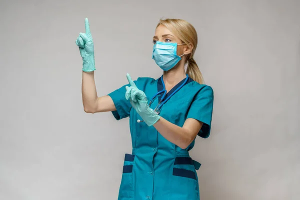 Enfermera médica mujer con máscara protectora y guantes de látex - trabajando con pantalla virtual — Foto de Stock